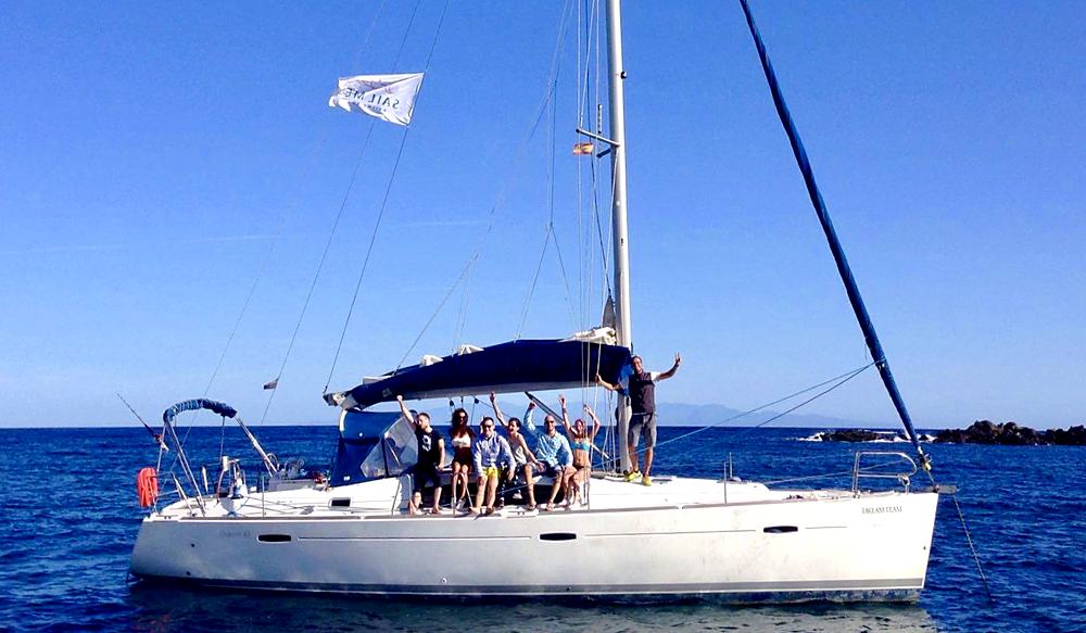 El grupo saludando desde la cubierta del velero fondeado