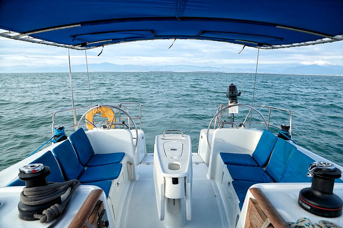 Bañera del velero con cojines azules y el mar de frente